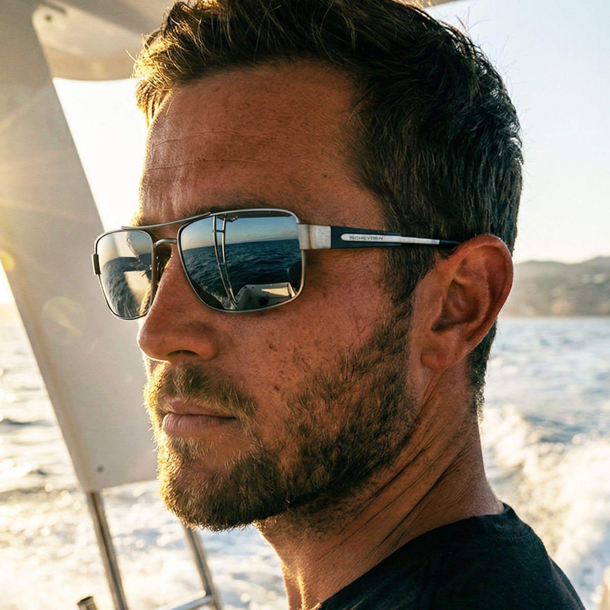 Man wearing reflective sunglasses with a blurred background of water and sky